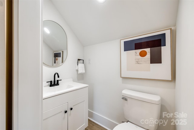 bathroom featuring toilet, hardwood / wood-style floors, and vanity