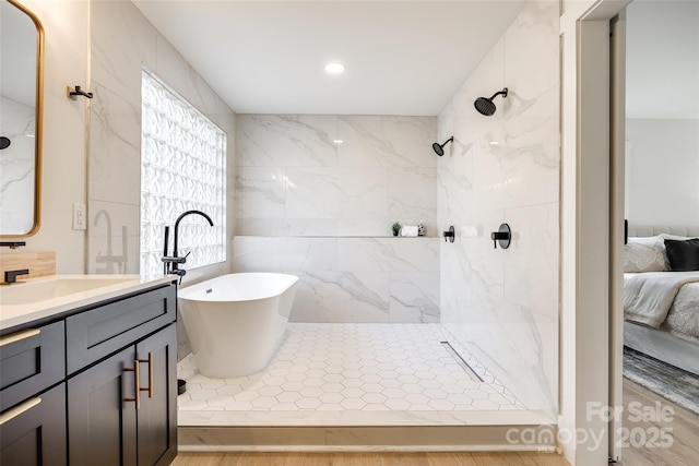 bathroom with a wealth of natural light, separate shower and tub, and vanity