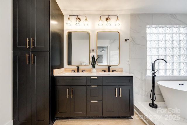 bathroom featuring vanity and a washtub