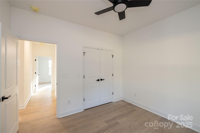 unfurnished bedroom featuring ceiling fan, a closet, and light hardwood / wood-style floors