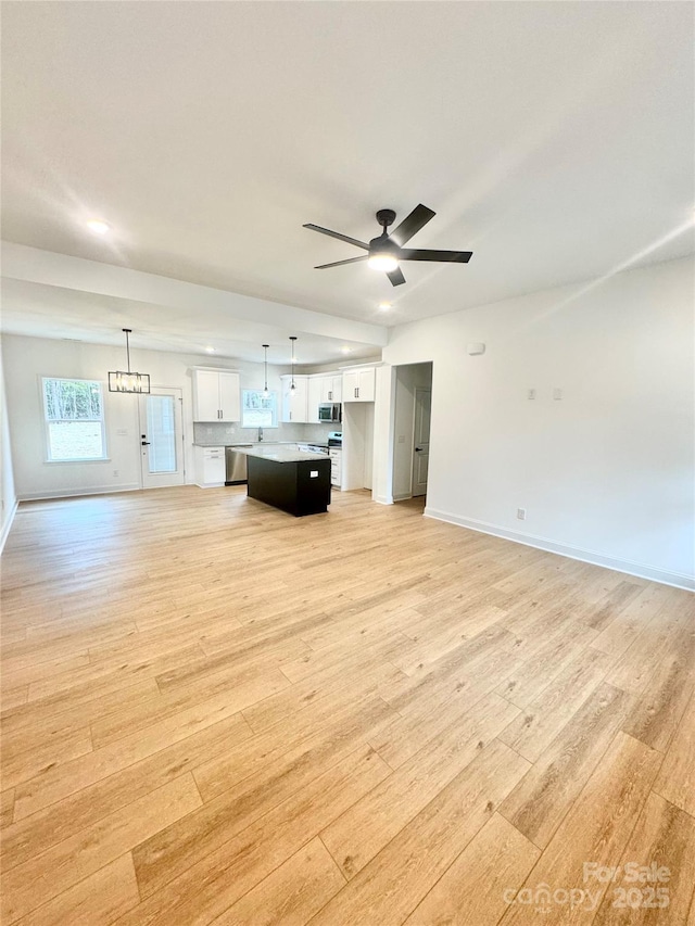 unfurnished living room featuring light hardwood / wood-style flooring and ceiling fan