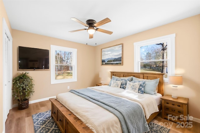 bedroom with a ceiling fan, baseboards, and wood finished floors