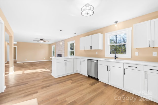 kitchen with a wealth of natural light, white cabinets, dishwasher, and a sink