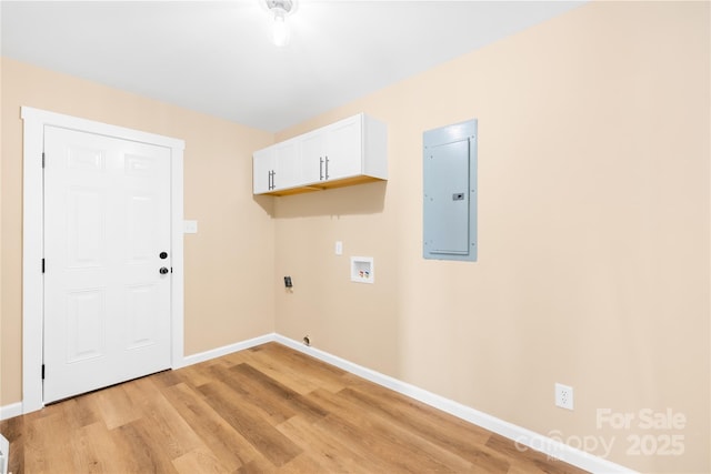 laundry area with light wood-type flooring, washer hookup, electric panel, cabinet space, and baseboards