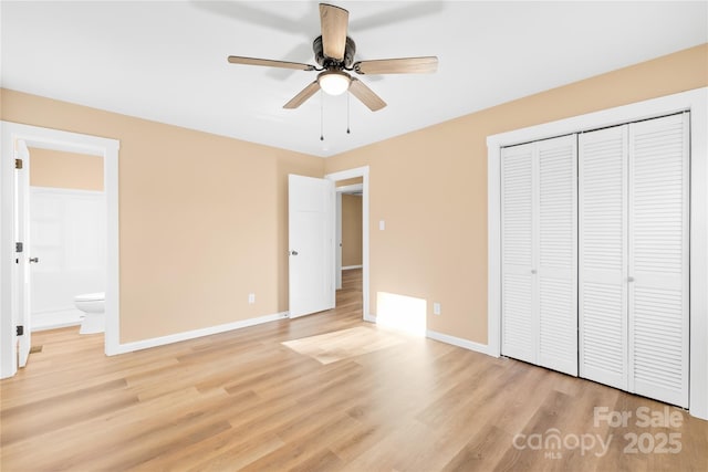 unfurnished bedroom with ensuite bath, light wood-style flooring, baseboards, and a closet