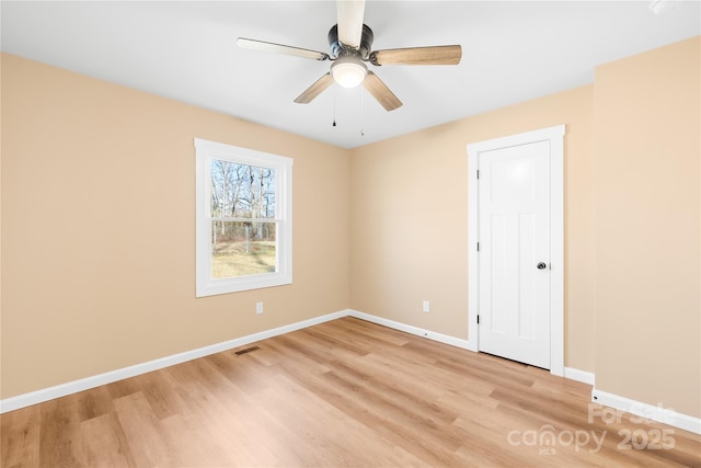 unfurnished room featuring baseboards, visible vents, light wood finished floors, and ceiling fan