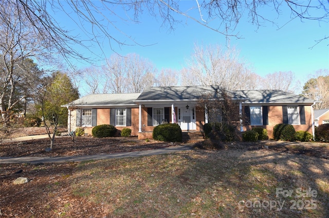 ranch-style house with a porch and a front yard