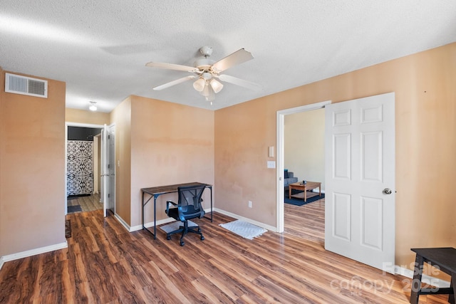 office space featuring ceiling fan, a textured ceiling, and dark hardwood / wood-style flooring