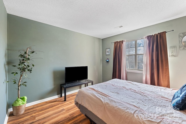 bedroom featuring a textured ceiling and hardwood / wood-style floors