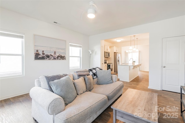 living room with a notable chandelier and hardwood / wood-style floors