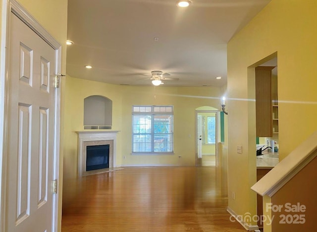 unfurnished living room with ceiling fan and wood-type flooring