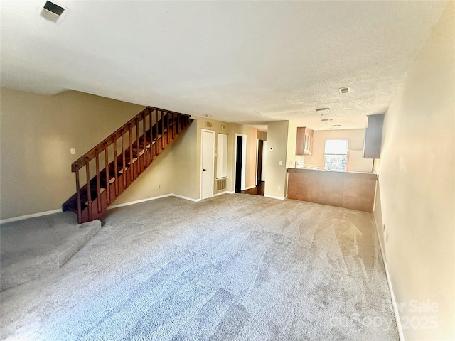 unfurnished living room with carpet and a textured ceiling