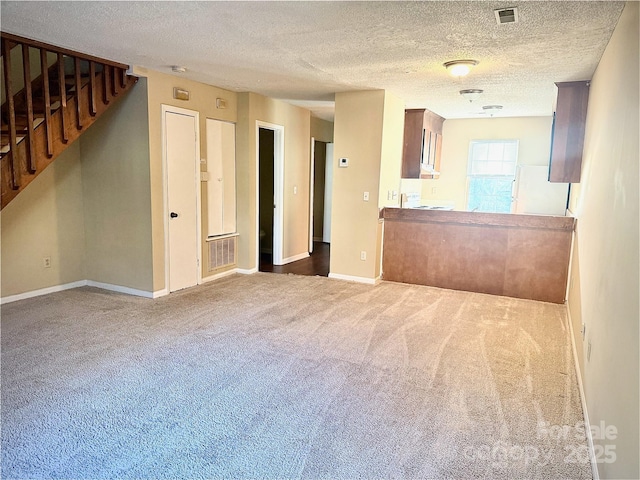 unfurnished living room featuring carpet and a textured ceiling