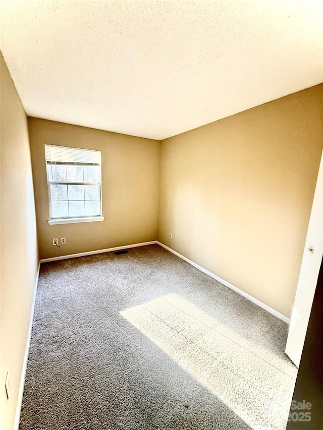 carpeted empty room with a textured ceiling