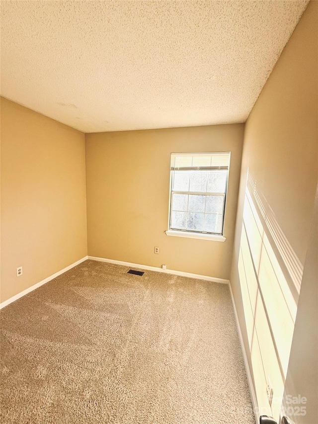 carpeted empty room with a textured ceiling