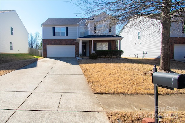 view of property with a garage, a front yard, and covered porch