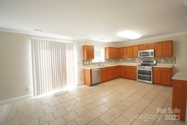 kitchen with appliances with stainless steel finishes, sink, decorative backsplash, ornamental molding, and light tile patterned floors