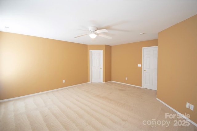 unfurnished room with light colored carpet and ceiling fan