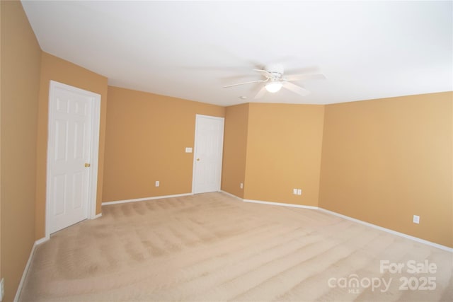 carpeted spare room featuring ceiling fan