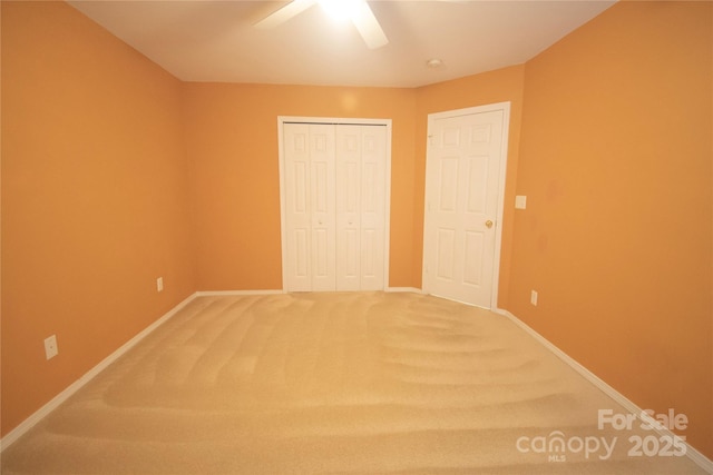 unfurnished bedroom featuring ceiling fan, a closet, and carpet