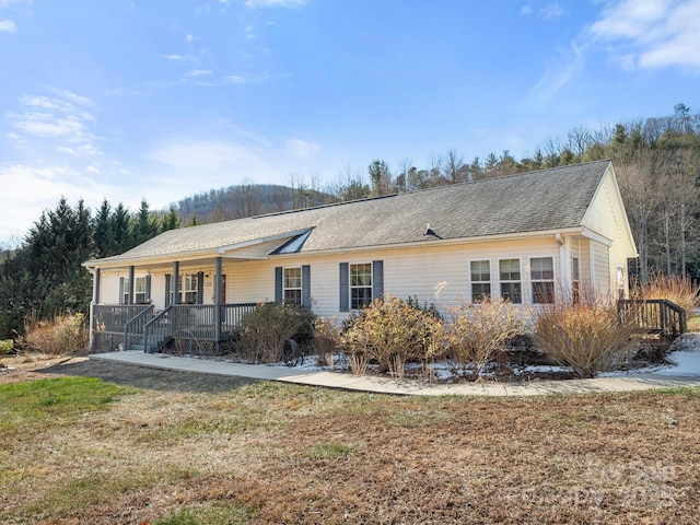 single story home featuring covered porch and a front yard