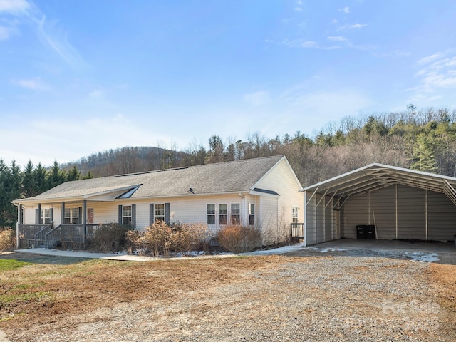 ranch-style home with a porch and a carport