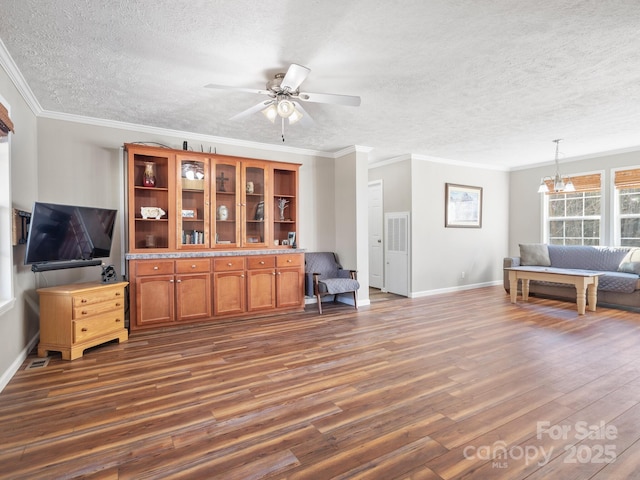 living room with a textured ceiling, ornamental molding, ceiling fan with notable chandelier, and dark hardwood / wood-style floors