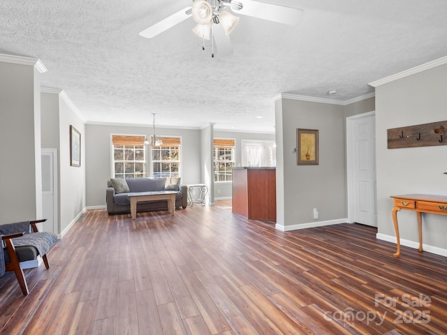 unfurnished living room with dark wood-type flooring, ceiling fan with notable chandelier, crown molding, and a textured ceiling