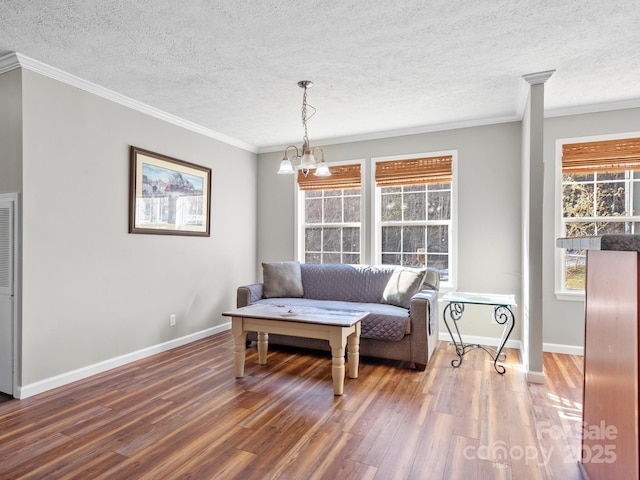 living area featuring a chandelier, plenty of natural light, and ornamental molding