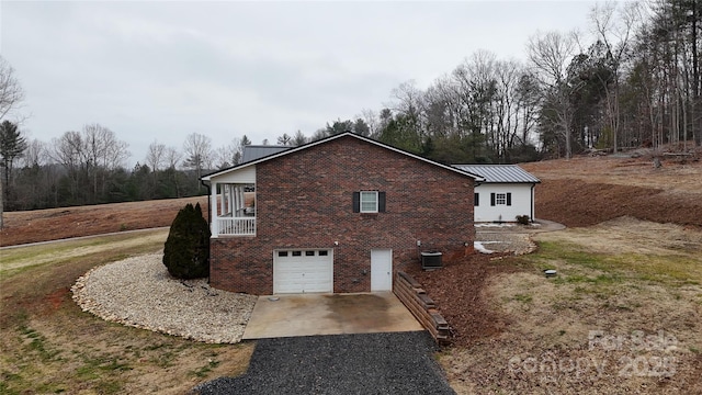 view of home's exterior featuring a garage and central AC