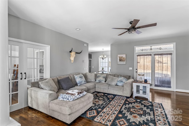 living room featuring ceiling fan with notable chandelier, dark hardwood / wood-style flooring, and french doors