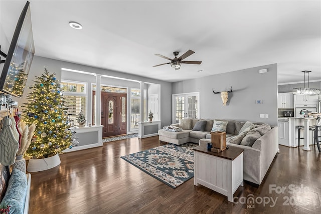 living room featuring ceiling fan, dark hardwood / wood-style floors, and ornate columns