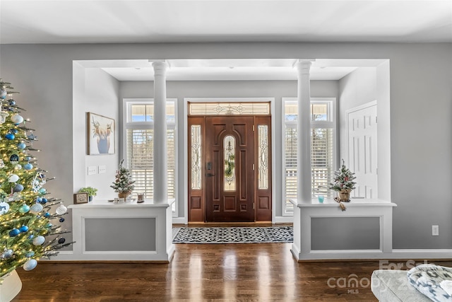 entrance foyer featuring dark hardwood / wood-style floors and ornate columns