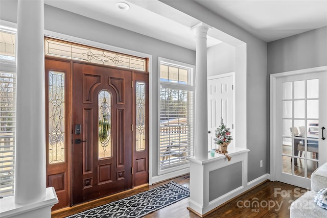 foyer entrance featuring dark hardwood / wood-style flooring and decorative columns