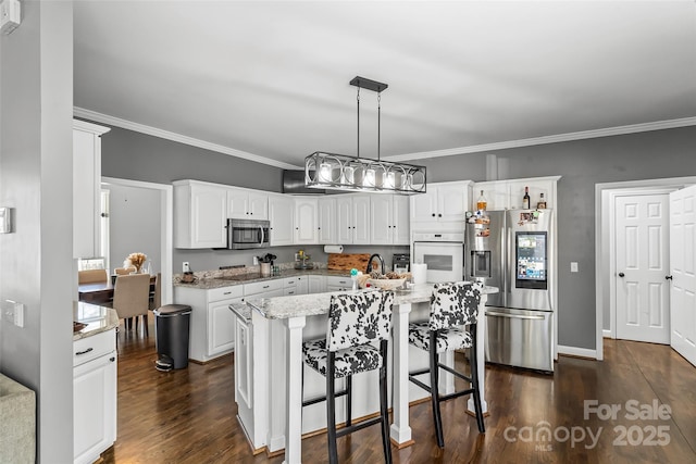 kitchen with white cabinetry, stainless steel appliances, light stone countertops, and hanging light fixtures