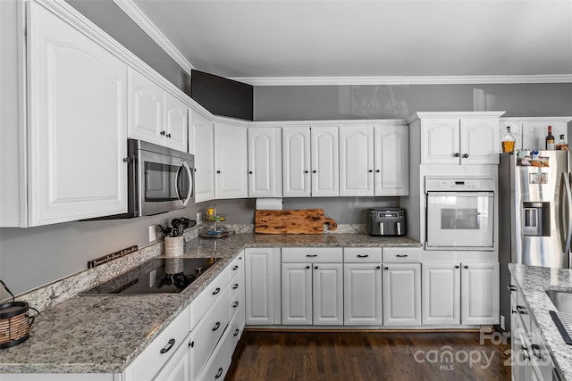 kitchen with light stone countertops, stainless steel appliances, and white cabinets