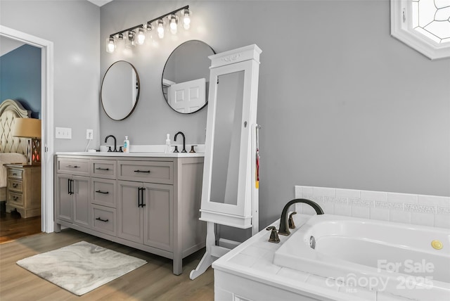 bathroom featuring vanity, a bathtub, and wood-type flooring