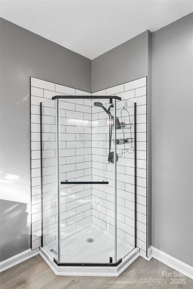 bathroom featuring wood-type flooring and a shower with shower door