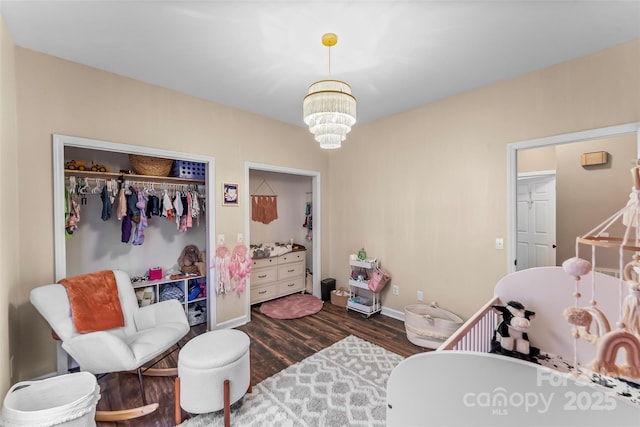 bedroom featuring a notable chandelier, dark wood-type flooring, and a closet