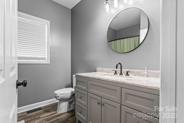 bathroom featuring vanity, wood-type flooring, and toilet