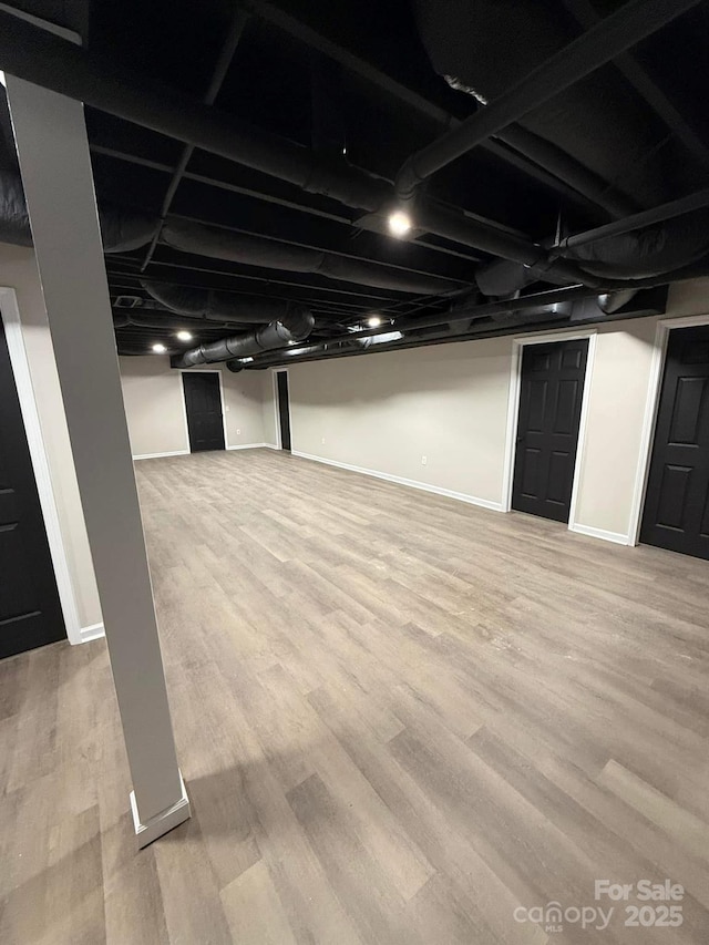 basement with light hardwood / wood-style flooring