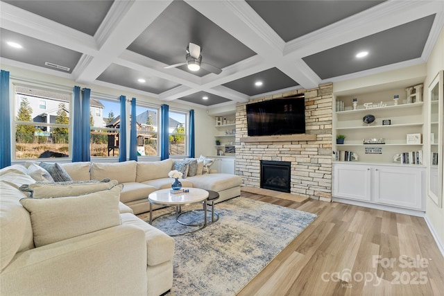 living room with built in shelves, ornamental molding, a fireplace, and beam ceiling