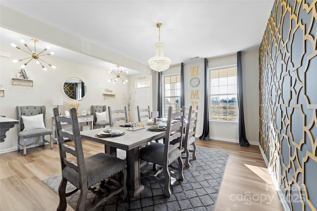 dining space with a chandelier and light hardwood / wood-style flooring