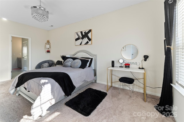 bedroom with light carpet, ensuite bath, and multiple windows