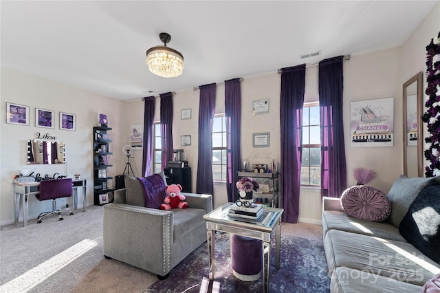 living room with carpet floors and a notable chandelier