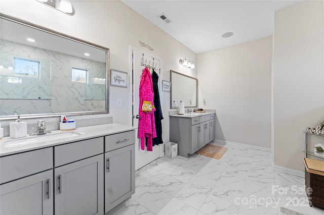 bathroom with tiled shower and vanity