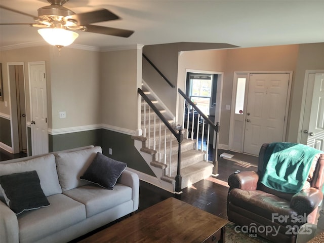 living room with crown molding, stairway, ceiling fan, wood finished floors, and baseboards