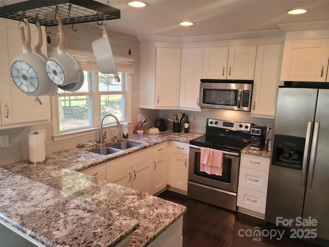 kitchen featuring appliances with stainless steel finishes, white cabinetry, and a sink