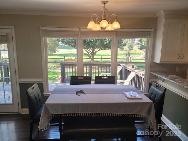 dining area featuring plenty of natural light, ornamental molding, and a chandelier