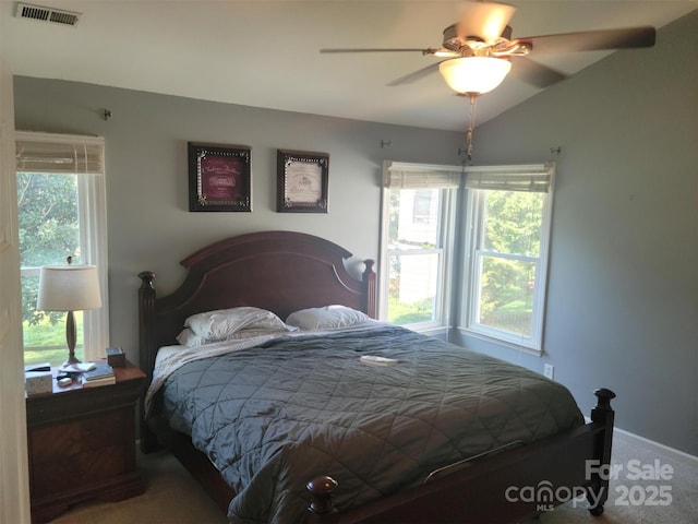 carpeted bedroom featuring vaulted ceiling, visible vents, and a ceiling fan